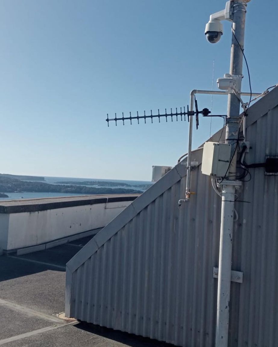 Rooftop antenna and security camera installed with a harbour view