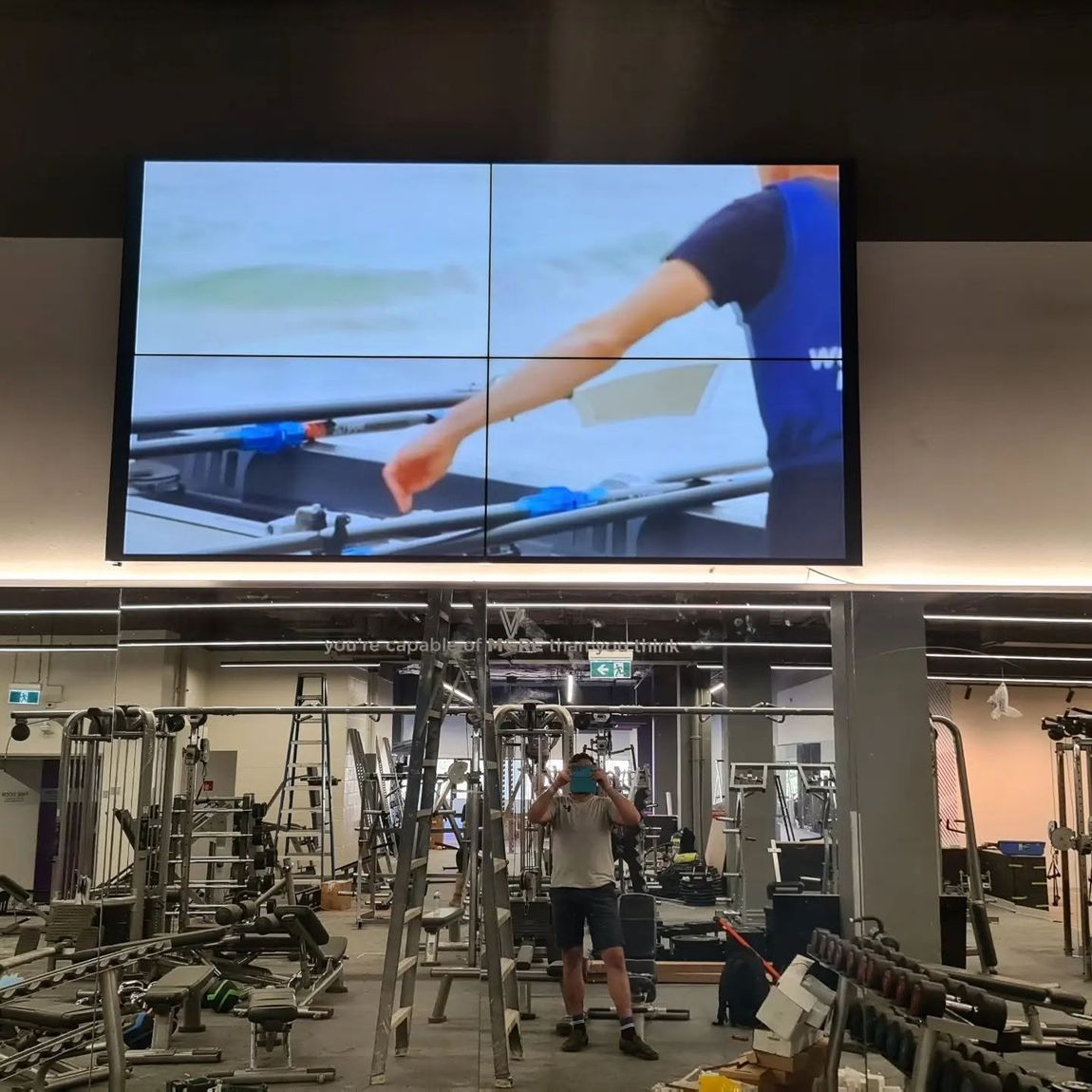 Large video wall installed above commercial gym equipment