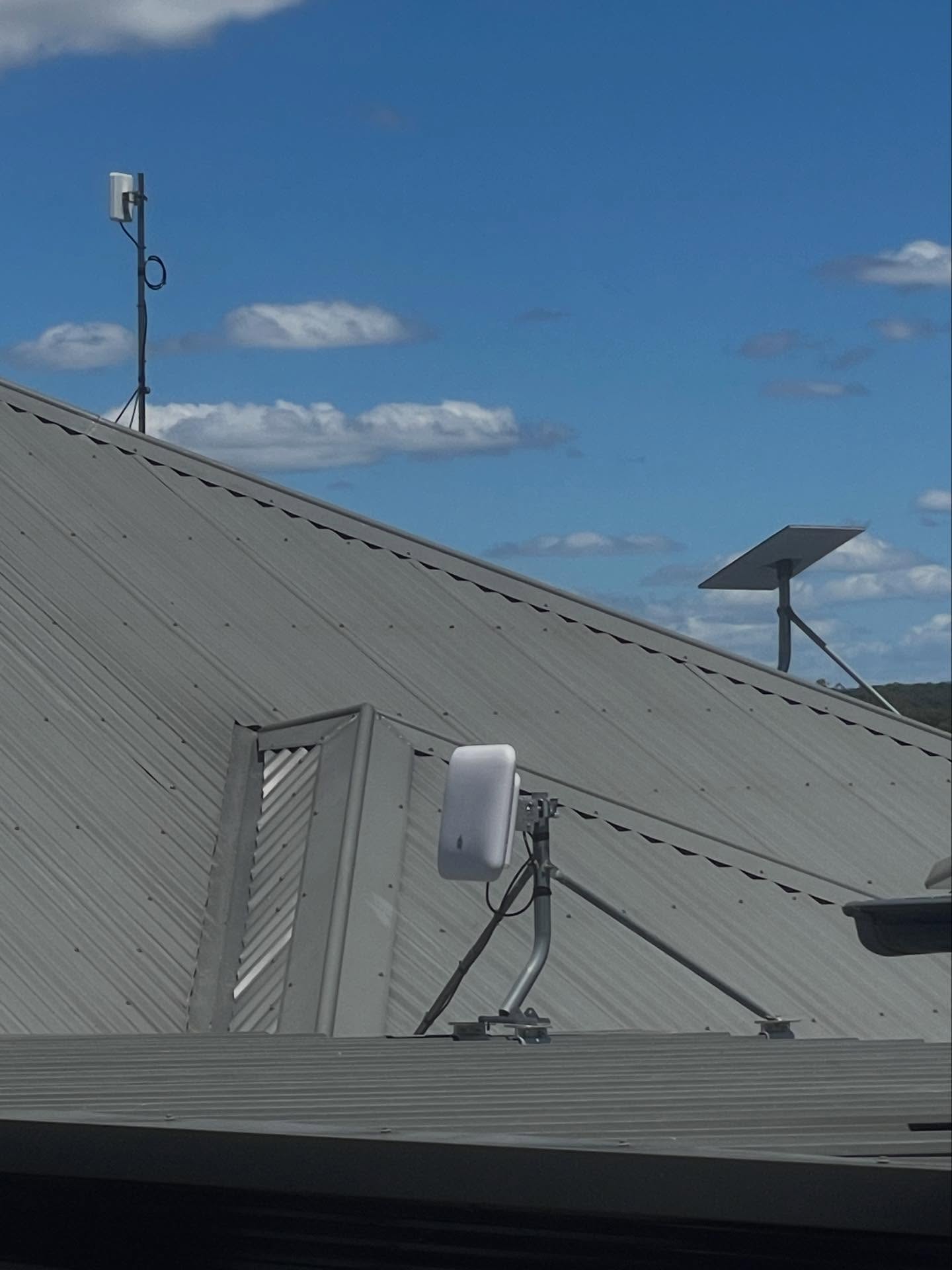 Starlink dish and point-to-point wireless antenna installed on a roof