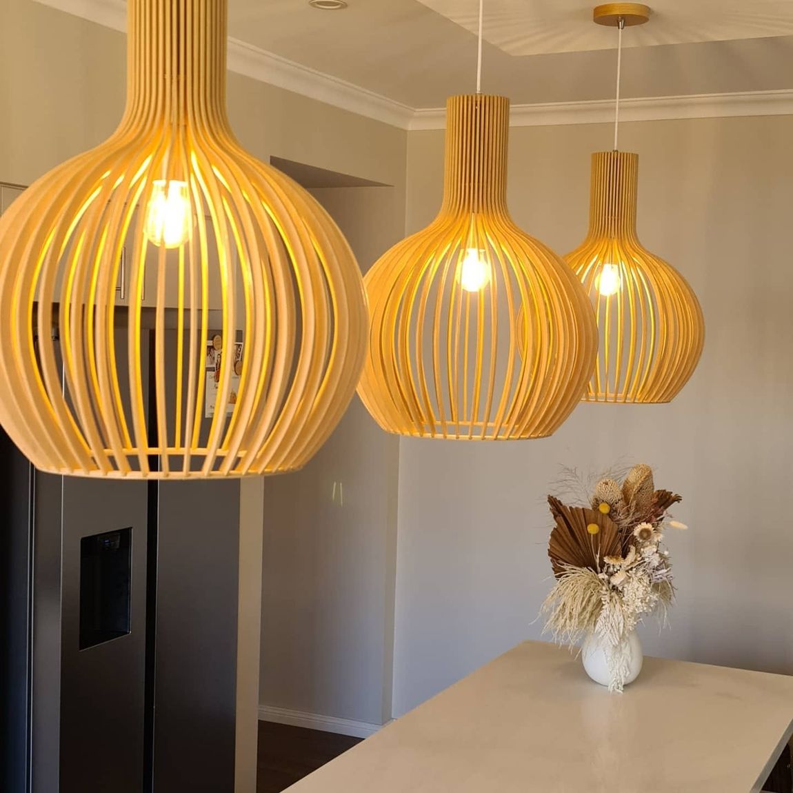 Timber slat pendant lights over a kitchen bench