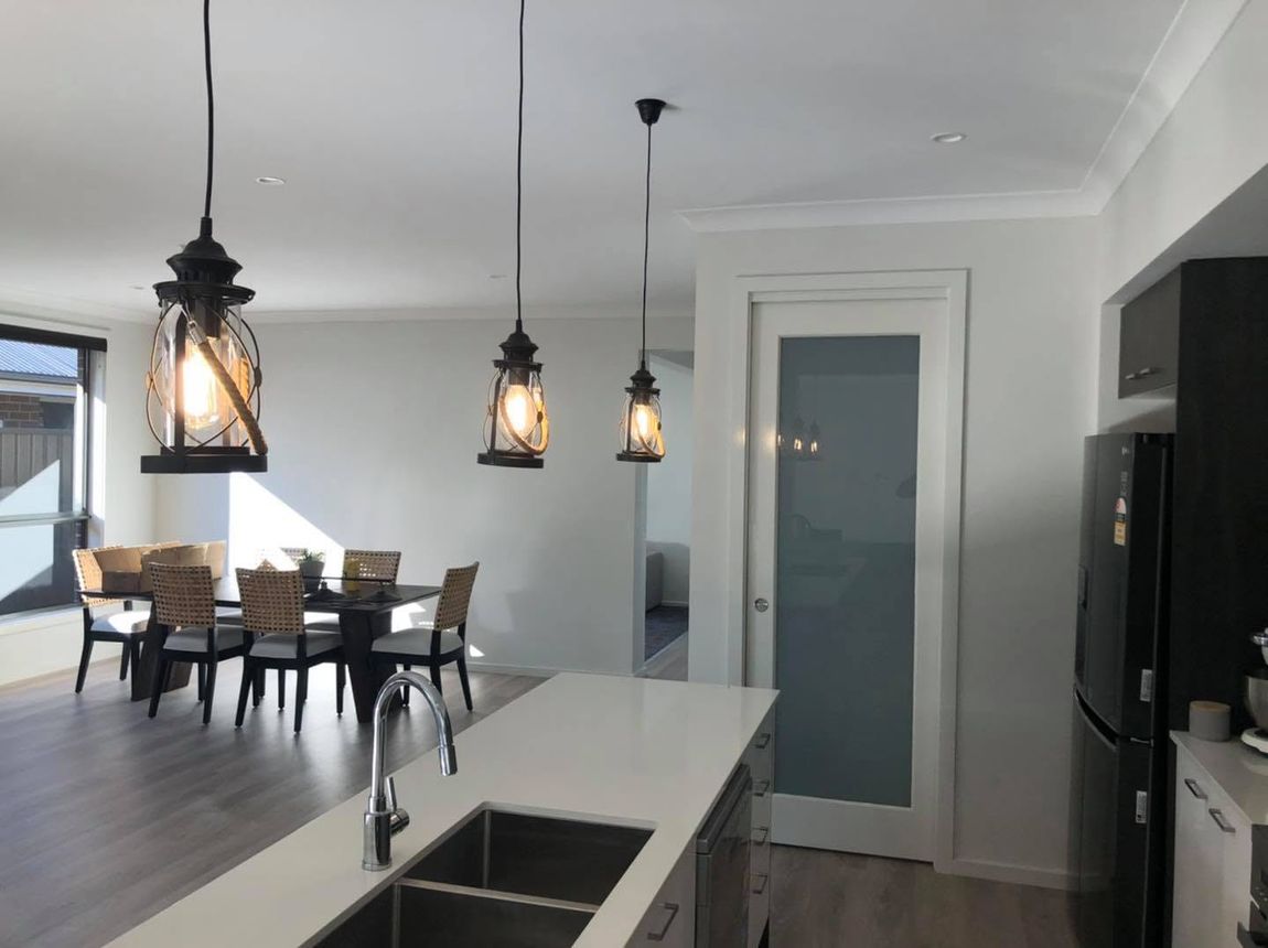 Black lantern-style pendant lights over a kitchen island