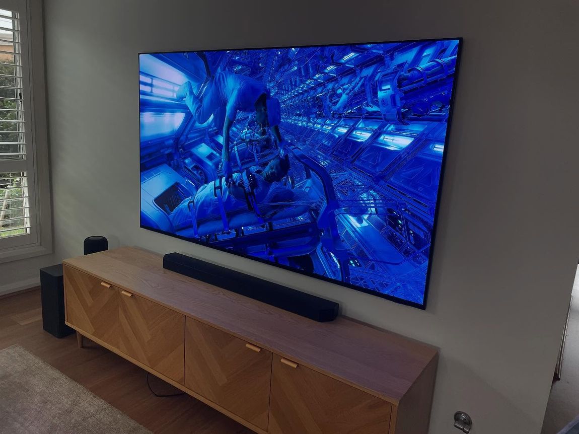 Large wall-mounted TV with soundbar in a living room