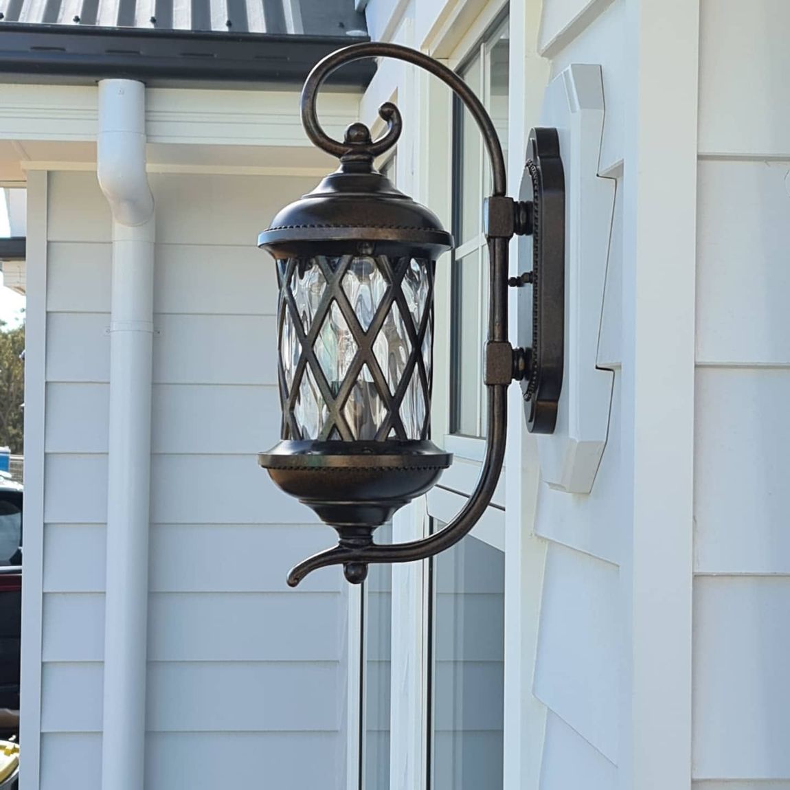 Outdoor lantern-style wall light installed beside a front window